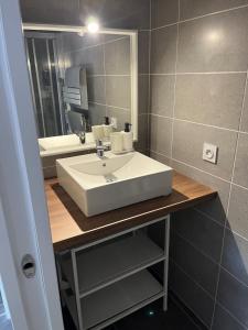 a bathroom with a white sink and a mirror at Ampuis centre - Appartement indépendant in Ampuis