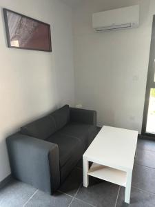a living room with a couch and a table at Ampuis centre - Appartement indépendant in Ampuis
