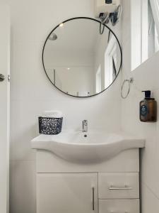 a white bathroom with a sink and a mirror at Charming 1 bedroom, park adjacent. city 5 minutes in Sydney +13 photos