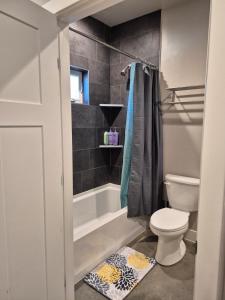 a bathroom with a toilet and a tub and a sink at Bluff 11 Professional Housing in Delta +3 photos