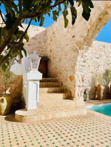 a set of stairs next to a wall with a pool at Superbe ! Riad ALBAYDA Suite & Rooftop in Essaouira