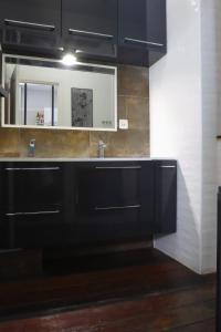 a bathroom with black cabinets and a mirror at Maison T3 - 2 chambres lits doubles in Lormont +15 photos