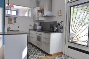a kitchen with white cabinets and a window at Maison T3 - 2 chambres lits doubles in Lormont
