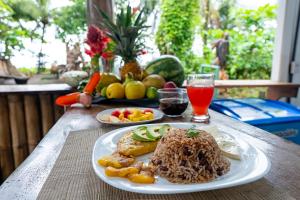 a table with a plate of food and a drink at El Deseo Serendipity Tortuguero in Tortuguero