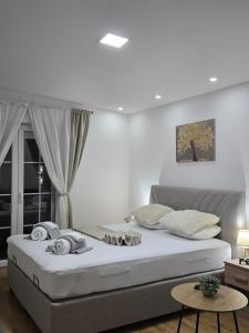 a bedroom with a large bed with white walls at Apartman Majdan in Mostar +6 photos
