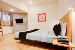 a bedroom with a large bed in a room at Townhouse Nagpur Junction Formerly Hotel Woodland in Nagpur