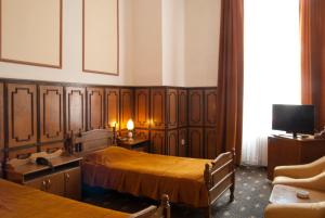 een hotelkamer met 2 bedden en een televisie bij Hotel Dacia in Lugoj