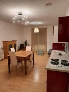 a kitchen and living room with a wooden table and a dining room at Logement indépendant au cœur d'une ferme in Blandin