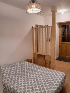 a bedroom with a bed and a wooden staircase at Logement indépendant au cœur d'une ferme in Blandin