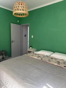 a bedroom with a large bed with a green wall at Las moras saladillo in Saladillo