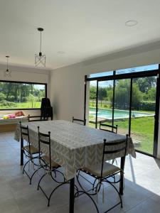 a dining room with a table and chairs and windows at Las moras saladillo in Saladillo