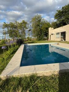 a swimming pool in front of a house at Las moras saladillo in Saladillo