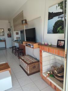 un salon avec une cheminée et une télévision dans l'établissement Apartamento Capão Novo, à Capão Novo 9 autres photos