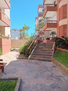 une passerelle devant un bâtiment avec des escaliers dans l'établissement Apartamento Capão Novo, à Capão Novo