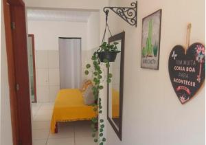 a room with a yellow bed and a mirror at Flat Kactus in Itacaré