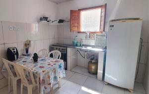 a small kitchen with a table and a refrigerator at Flat Kactus in Itacaré +5 photos