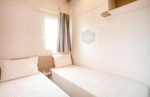 - 2 lits dans une chambre avec un panneau mural dans l'établissement Casa Nature's Avlis Bungalow 4XZ, à Pataias 34 autres photos