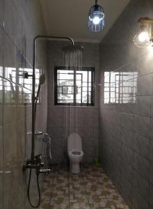 a bathroom with a shower and a toilet at Materuni Home Stay in Uru East +16 photos