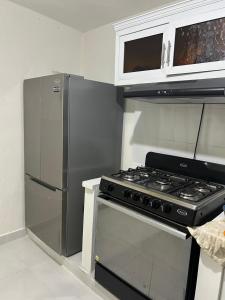 a kitchen with a stove and a refrigerator at Eastern Breeze in Hainamosa
