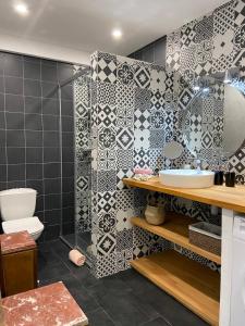 a bathroom with a shower and a toilet and tiles at Le jardin du Griffoul in Nébias +38 photos