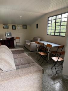 a living room with a bed and a table and chairs at Sítio Bela Vista in Areado