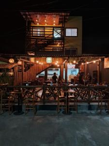 a restaurant with wooden tables and chairs at night at 14 Bis Hospedagem in Arembepe