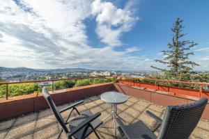 a patio with two chairs and a table on a balcony at Tranquil Hideaway on Gellért Hill with Parking in Budapest