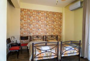 a bedroom with two beds in front of a brick wall at Nomads Rooms in Tríkala