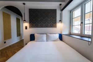 a bedroom with a large white bed with a window at Prisma - Univers du jeux in Chagny +13 photos