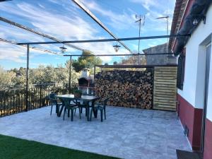 a patio with a table and chairs and a fence at El Almendro de Fuentes Nuevas in Castril