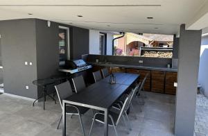 a dining room with a table and chairs and a kitchen at Silver Chill Apartman in Abádszalók