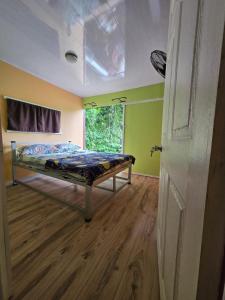 a bedroom with a bed in a room with a window at CocoRelax in Siquirres