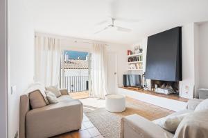ein Wohnzimmer mit Sofa und Flachbildfernseher in der Unterkunft Apartment Boutique Hort in Cadaqués