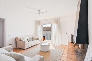 カダケスにあるApartment Boutique Hortのソファとテーブルのある白いリビングルーム