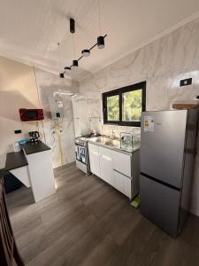 La cuisine est équipée d'un réfrigérateur et d'un évier. dans l'établissement Cabaña Vista ShangriLa, Las Trancas, à Las Trancas