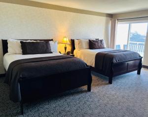 a hotel room with two beds and a window at North Cliff Hotel in Fort Bragg
