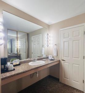 a bathroom with a sink and a large mirror at North Cliff Hotel in Fort Bragg