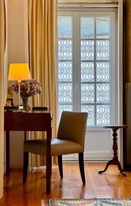 a desk and a chair in front of a window at Casa das Laranjas in Porto