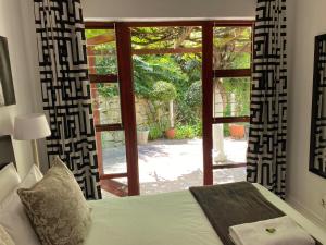 - une chambre avec un lit en face d'une fenêtre dans l'établissement Valley Heights Guest House and B & B, au Cap