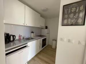 a kitchen with white cabinets and a chalkboard on the wall at T3 Expo Sud-Est - Parking - Piscine - Clim - Wifi in Gruissan