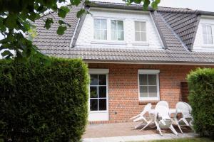 a group of white chairs in front of a house at Ferienhof-Kirschenholz in Schillsdorf