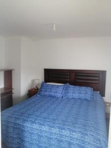 un letto con un piumone blu in una camera da letto di Hermosa casa BOSQUE PLAYA a El Cerrillo