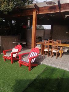 2 sedie rosse e un tavolo in un patio di Hermosa casa BOSQUE PLAYA a El Cerrillo