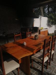 un tavolo di legno con sedie intorno e una griglia di Hermosa casa BOSQUE PLAYA a El Cerrillo