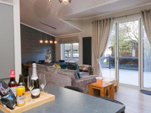 ein Wohnzimmer mit einem Sofa und einem Tisch mit Weingläsern in der Unterkunft 7 Lake View in Troutbeck Bridge