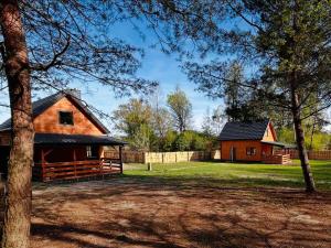 a barn and a house with a yard at Bolek i Lolek domki do wynajęcia in Popielżyn Dolny