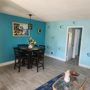 a dining room with blue walls and a table and chairs at Jubilee Gardens Freeport in Freeport