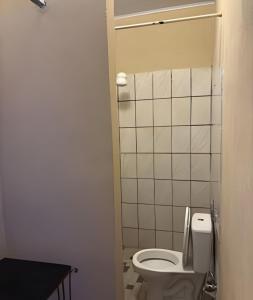 ein Badezimmer mit Toilette und gefliester Wand in der Unterkunft Residência j&m in São Luís
