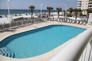 a large swimming pool with chairs and the beach at TradeWinds 102 in Romar Beach