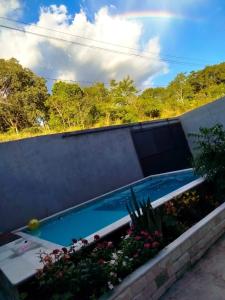 ein Swimmingpool in einem Garten mit Blumen und Pflanzen in der Unterkunft Casa refúgio da paz in Pirenópolis